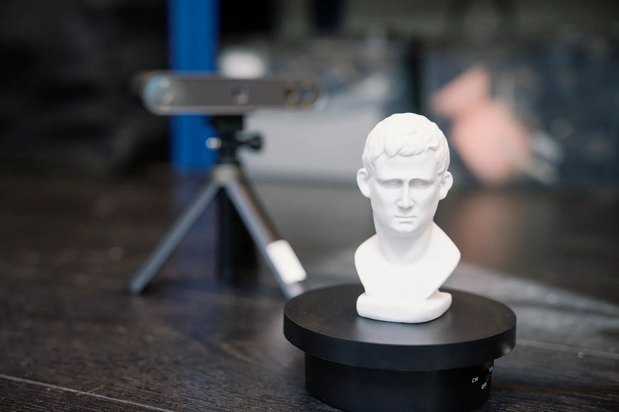 A 3D scanner on a tripod capturing a plaster bust in the Spike TM studio